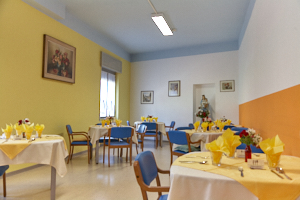 Sala ristorante apparecchiata con tavoli e sedute