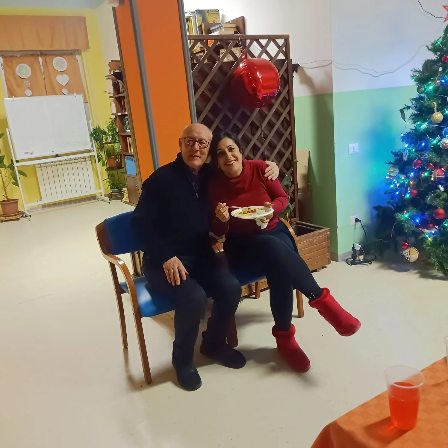 Ospite e visitatrice sorridono accanto all’albero di Natale
